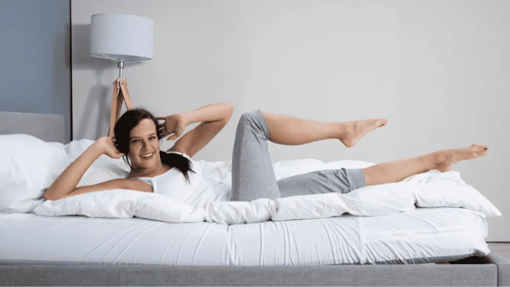 A side view of a person performing ab cycle on a bed, illustrating an effective exercise to target the lower abdominal muscles. Explore the world of bed-friendly ab workouts to sculpt and tone your stomach for a sleeker appearance
